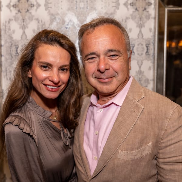 Smiling man and woman posing together in front of a patterned wall at Darvish Kitchen.